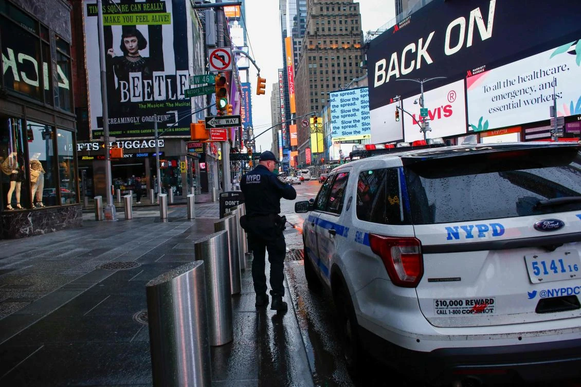 A NYPD officer patrols Times Square as rain falls on March 28, 2020 in New York City. US President Donald Trump said on March 28, 2020 that he’s considering a short-term quarantine of New York state, New Jersey, and parts of Connecticut. (AFP)