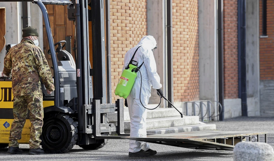 Military personnel disinfects a pallet outside a church in Seriate, Italy. (AFP)