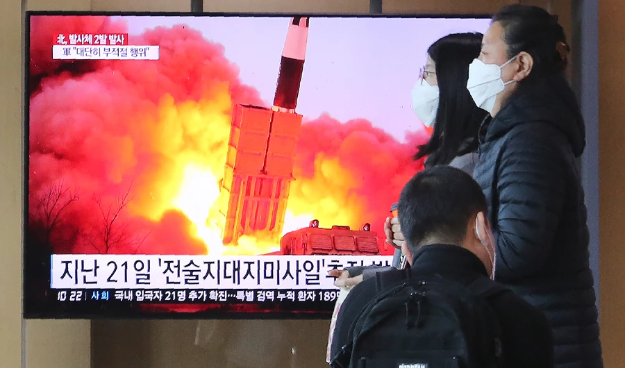 People pass by a TV screen showing a file image of North Korea's missile launch during a news program at the Seoul Railway Station in Seoul, South Korea, Sunday, March 29, 2020. (AP)