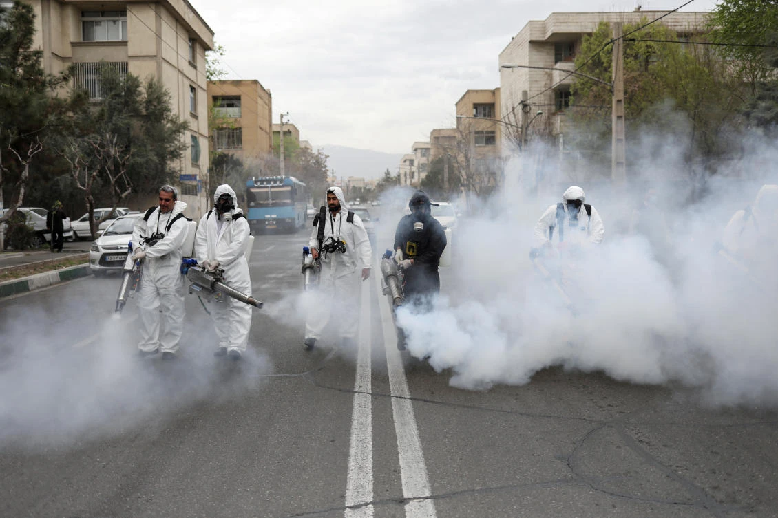 Firefighters wear protective face masks as they disinfect the streets in Tehran on March 18, 2020. Iran has reported more than 38,000 infections and 2,640 deaths from the coronavirus. (West Asia News Agency via Reuters)