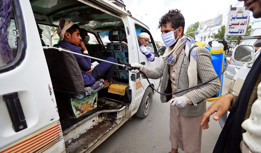 A Yemeni volunteer disinfects the interior of a public transportaion van in the capital Sanaa, amid concerns over the spread of the novel coronavirus, on March 28, 2020. (AFP)