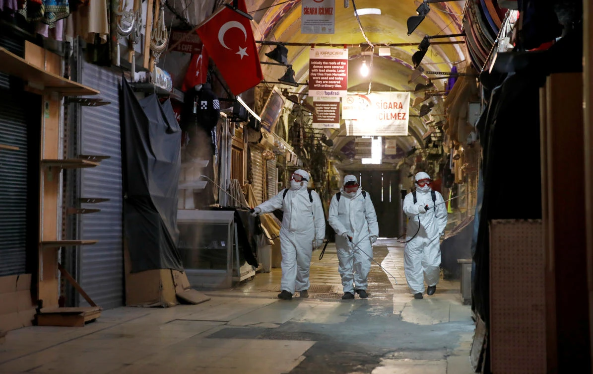 Workers in protective suits spray disinfectant at Grand Bazaar, known as the Covered Bazaar, to prevent the spread of coronavirus disease in Istanbul. (Reuters)