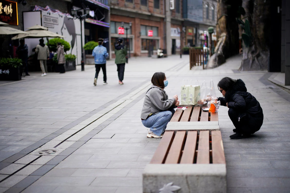 People eat on a bench at a shopping complex in Wuhan, Hubei province, the epicentre of China's coronavirus disease (COVID-19) outbreak, March 31, 2020. (Reuters/Aly Song)