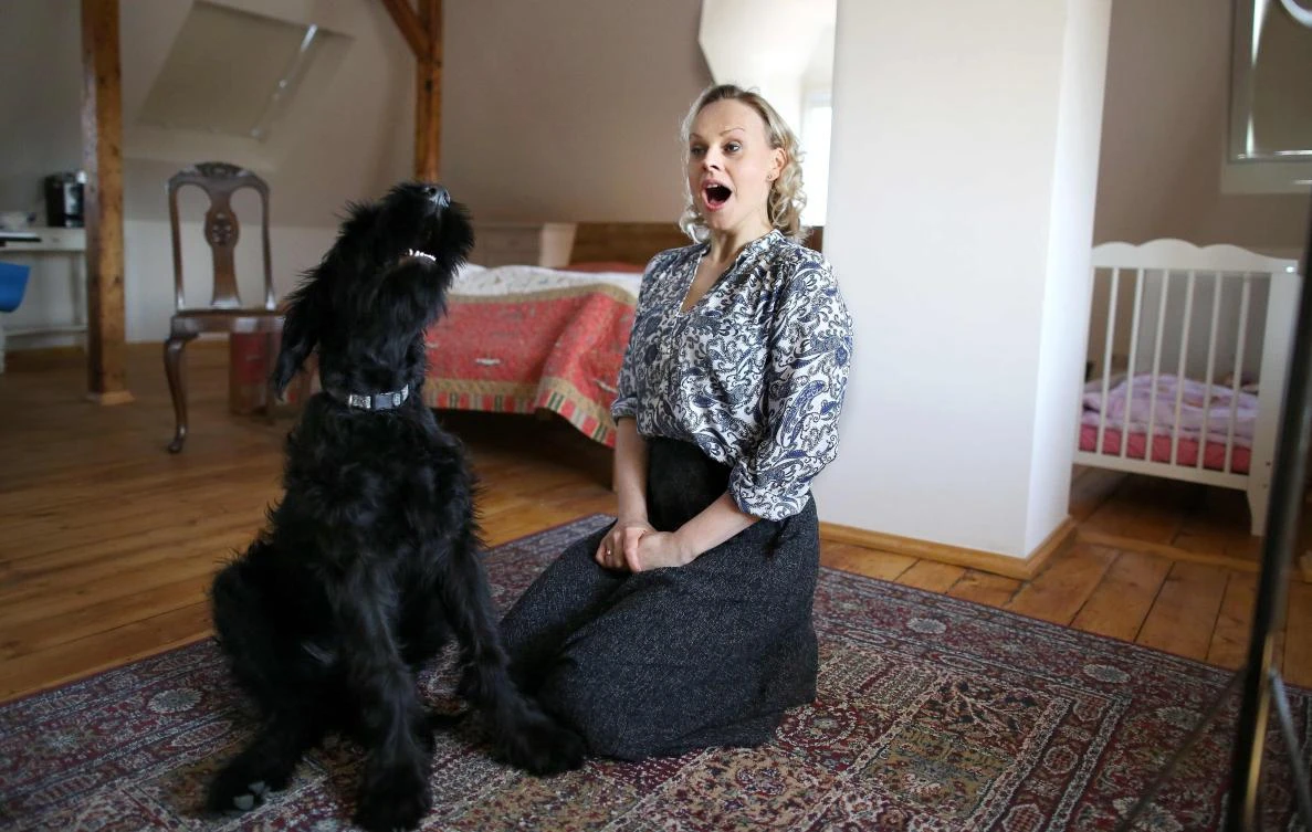 German sopranist and member of the ensemble of Leipzig's opera house (Oper Leipzig), Lilli Wuenscher sit next to her dog at home, where the family stays confined due to the pandemic of the novel coronavirus, on April 3, 2020 on the outskirts of Leipzig, eastern Germany. The gates of the Leipzig Opera have been closed for about three weeks due to the novel corona pandemic - but the voices and instruments of the artists are far from silent. / AFP / Ronny Hartmann