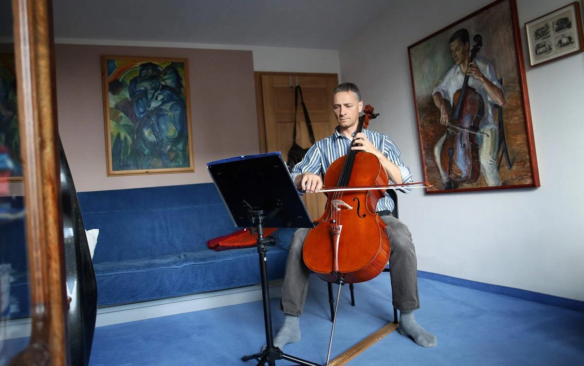 German musician Stephan Wuensch, principal cellist of Leipzig's opera house (Oper Leipzig), plays the violoncello at home, where he stays confined with his family due to the pandemic of the novel coronavirus, on April 3, 2020 on the outskirts of Leipzig, eastern Germany. The gates of the Leipzig Opera have been closed for about three weeks due to the novel corona pandemic - but the voices and instruments of the artists are far from silent. / AFP / Ronny Hartmann