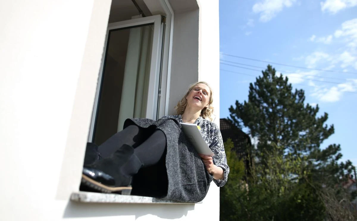 German sopranist and member of the ensemble of Leipzig's opera house (Oper Leipzig), Lilli Wuenscher sings at the window of her home, where she stays confined with her family due to the pandemic of the novel coronavirus, on April 3, 2020 on the outskirts of Leipzig, eastern Germany. The gates of the Leipzig Opera have been closed for about three weeks due to the novel corona pandemic - but the voices and instruments of the artists are far from silent. / AFP / Ronny Hartmann