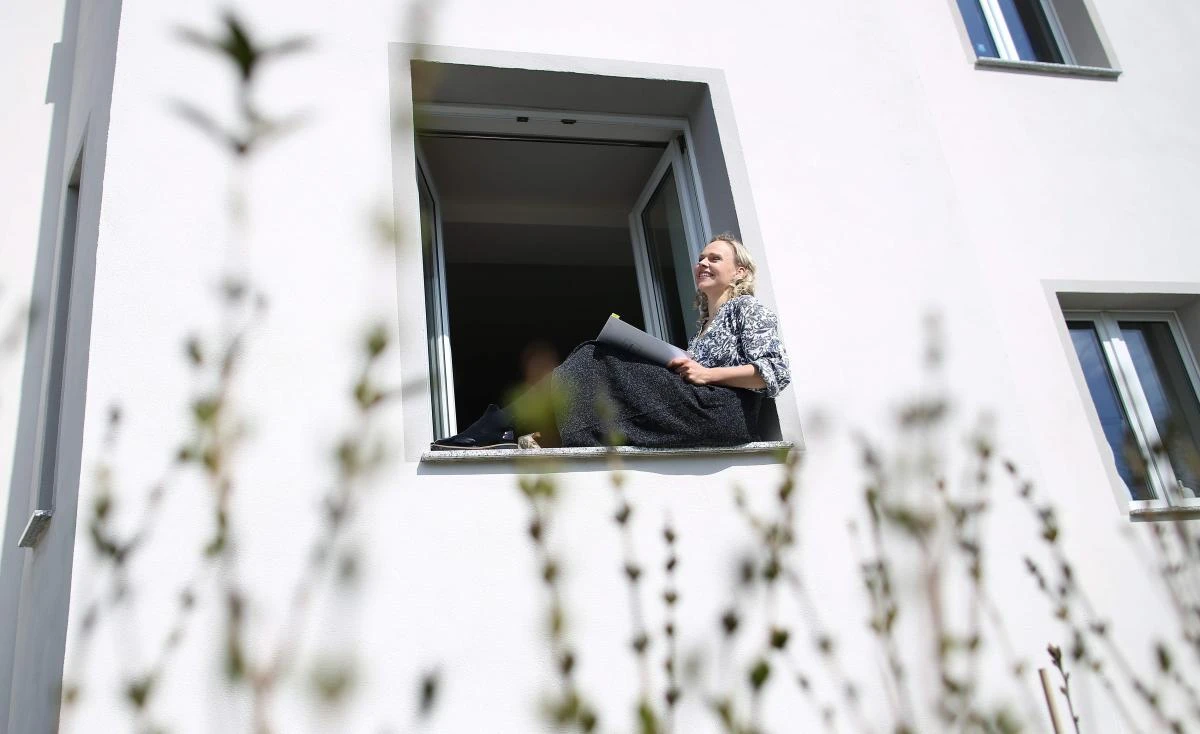German sopranist and member of the ensemble of Leipzig's opera house (Oper Leipzig), Lilli Wuenscher sings at the window of her home, where she stays confined with her family due to the pandemic of the novel coronavirus, on April 3, 2020 on the outskirts of Leipzig, eastern Germany. The gates of the Leipzig Opera have been closed for about three weeks due to the novel corona pandemic - but the voices and instruments of the artists are far from silent. / AFP / Ronny Hartmann