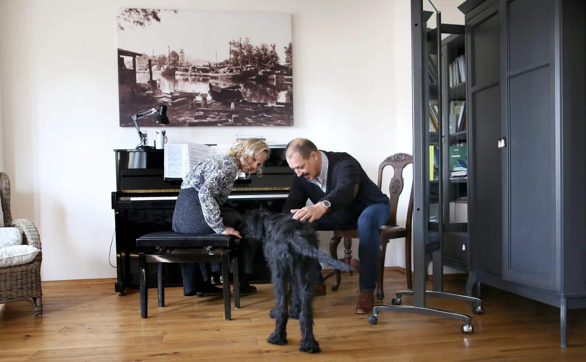 German sopranist and member of the ensemble of Leipzig's opera house (Oper Leipzig), Lilli Wuenscher and her husband Canadian bass Randall Jakobsh attend their dog at home, where the family stays confined due to the pandemic of the novel coronavirus, on April 3, 2020 on the outskirts of Leipzig, eastern Germany. The gates of the Leipzig Opera have been closed for about three weeks due to the novel corona pandemic - but the voices and instruments of the artists are far from silent. / AFP / Ronny Hartmann