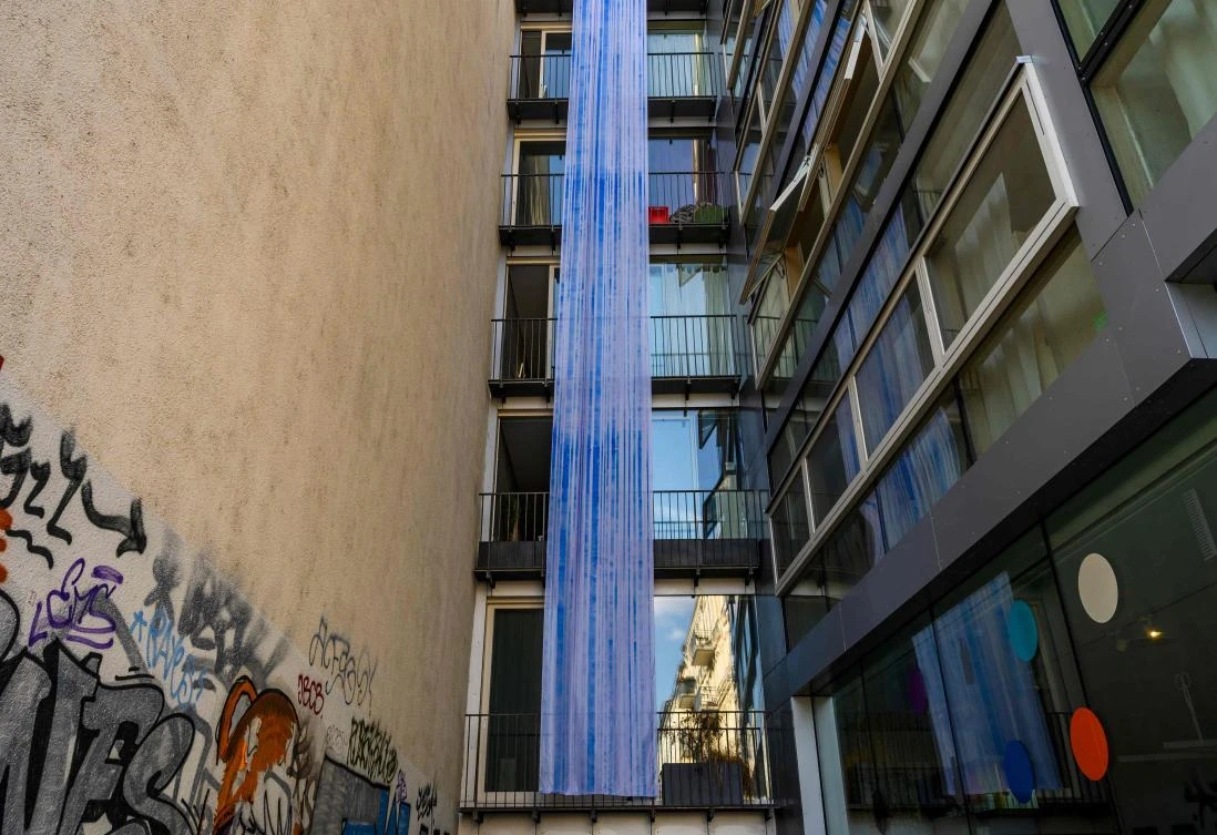 An art installation featuring a strip of fabric hanging from a balcony, part of the "Balconies, Life, Art, Pandemic, and Proximity" exhibition, is seen in Berlin on April 12, 2020, amid a new coronavirus COVID-19 pandemic. Over 30 artists are taking part in the two-day exhibition which calls on "the artistic community living in [Berlin's district of] Prenzlauer Berg to activate / exhibit / inhabit / their windows and balconies on Easter Sunday and Monday". Curated by Ovul Durmusoglu and Joanna Warsza, the exhibition boasts "zero budget, no openings, no crowds, just a proposition of a stroll that would connect dots in solidarity and togetherness". / AFP / John MACDOUGALL
