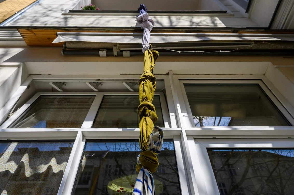 An art installation featuring fabric tied together to make a rope, part of the "Balconies, Life, Art, Pandemic, and Proximity" exhibition, is seen in Berlin on April 12, 2020, amid a new coronavirus COVID-19 pandemic. Over 30 artists are taking part in the two-day exhibition which calls on "the artistic community living in [Berlin's district of] Prenzlauer Berg to activate / exhibit / inhabit / their windows and balconies on Easter Sunday and Monday". Curated by Ovul Durmusoglu and Joanna Warsza, the exhibition boasts "zero budget, no openings, no crowds, just a proposition of a stroll that would connect dots in solidarity and togetherness". / AFP / John MACDOUGALL