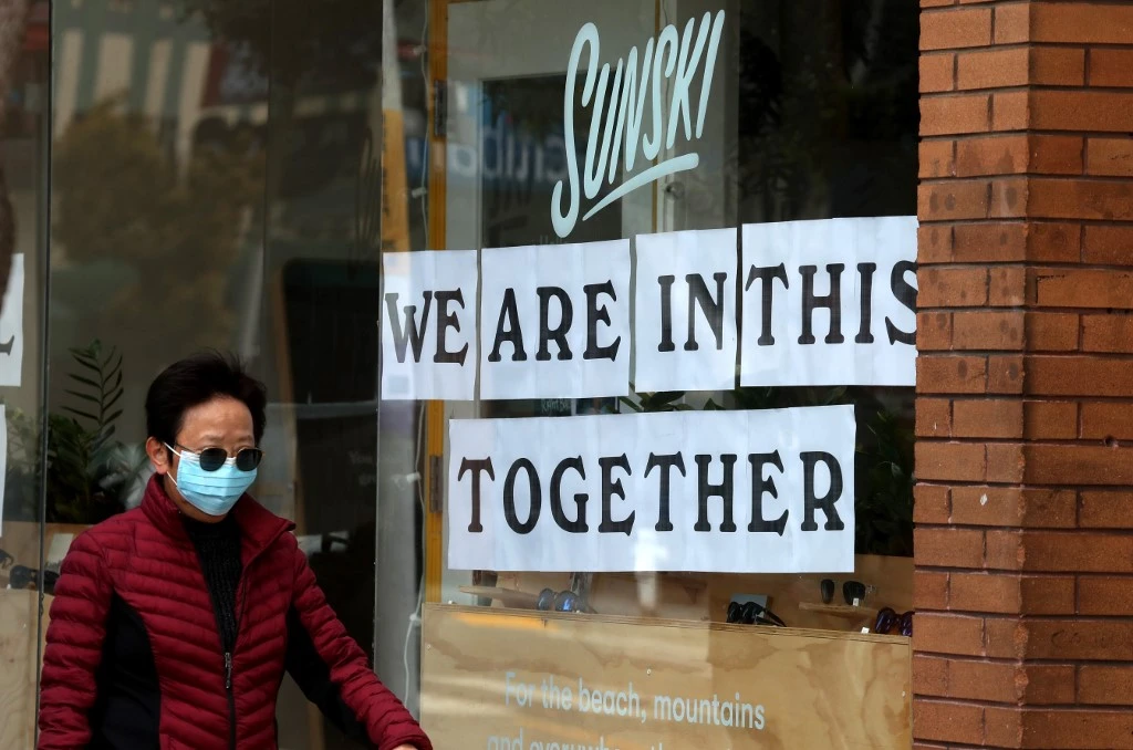 A pedestrian walks by a sign in the window of a store in San Francisco, California. The United States now hardest hit than any other country at almost 200,000 cases. (Getty Images via AFP)