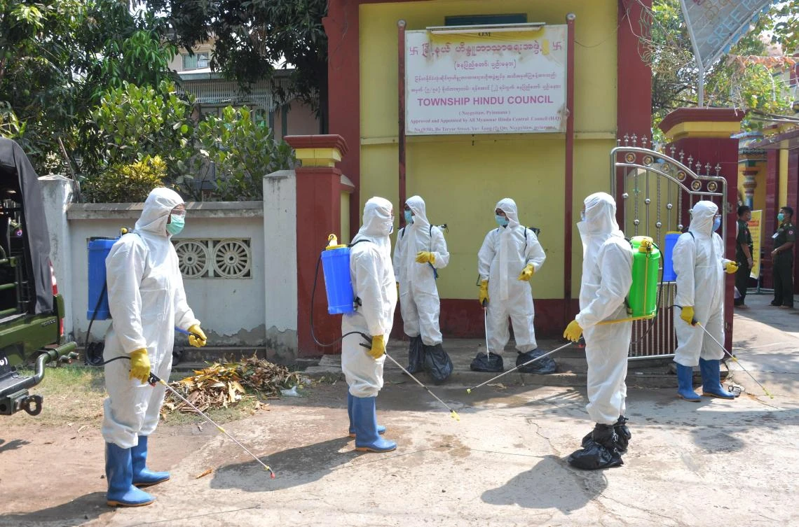 Myanmar military personnel wearing protective clothing prepare to disinfect a Hindu temple as a preventive measure to contain the spread of COVID-19 coronavirus in Naypyidaw on April 1, 2020. (AFP)