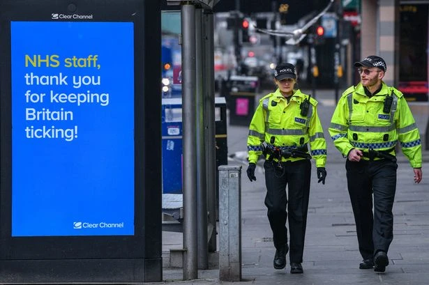 British police officers pass an information board thanking the NHS. (AFP)
