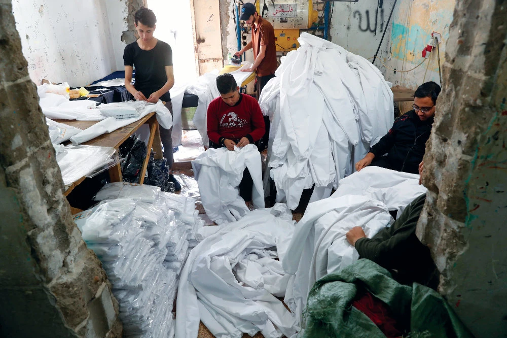 Palestinians in Gaza make protective overalls for export to Israel. AP