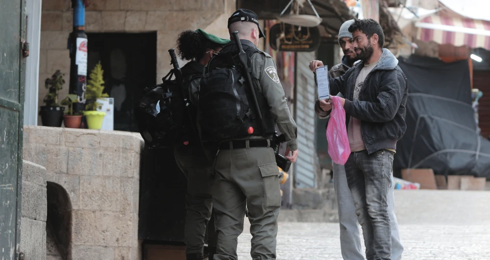 Israeli police check papers of Palestinians in Jerusalem’s Old City, as movements are limited to prevent the spread of the coronavirus disease (COVID-19). (AP)