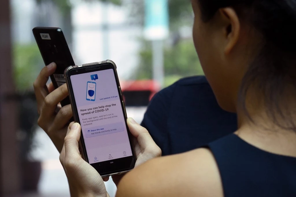 A resident tries out Singapore’s new contact-tracing smartphone app called TraceTogether, as a preventive measure against coronavirus in Singapore on March 20, 2020. A similar app in Britain is facing criticism over data privacy. (AFP)