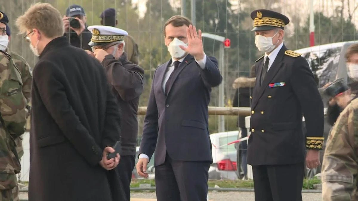 Emmanuel Macron arrives at the site of a field hospital set up, to treat coronanvirus patients, by the French army in the parking lot of an existing hospital in Mulhouse. (AFP screengrab)