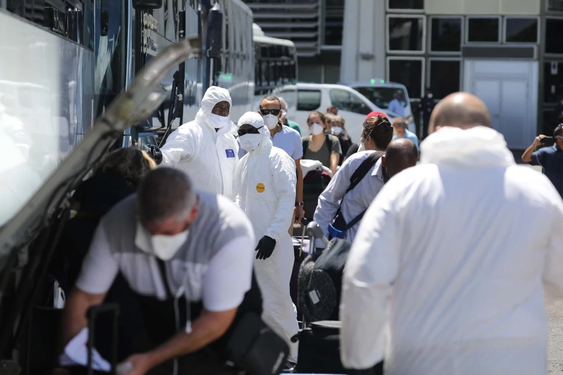 Passengers arrived from Paris prepare to board a bus taking them to a quarantine facility at Roland Garros airport in Saint-Denis de La Reunion on March 31, 2020. (AFP)