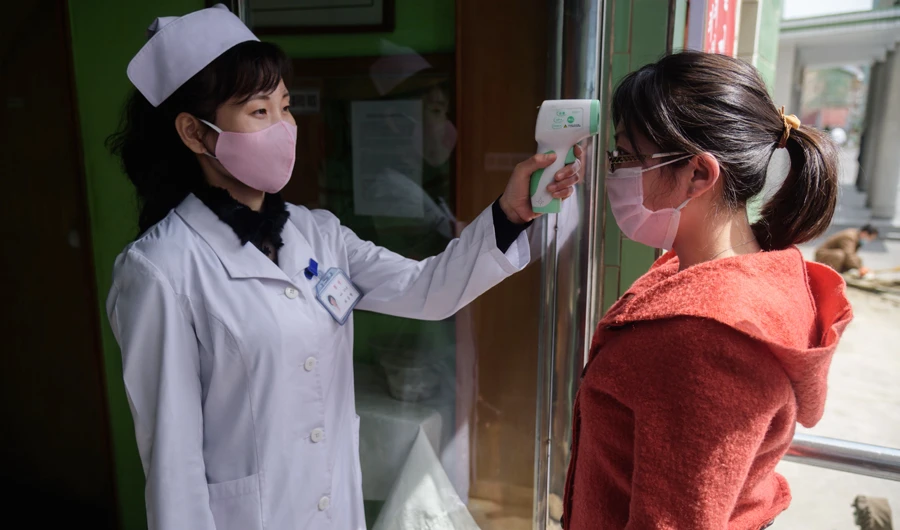 A nurse takes the temperature of a woman at an entrance of a Pyongyang hospital. (AFP)