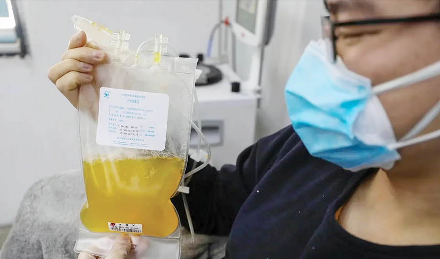 In this Feb. 18 photo, Dr. Zhou Min, a recovered COVID-19 patient who has passed his 14-day quarantine, donates plasma in Wuhan’s blood center in China’s Hubei province. Plasma from recovered COVID-19 patients contains antibodies that may help reduce the viral load in patients that are fighting the disease. (AP)