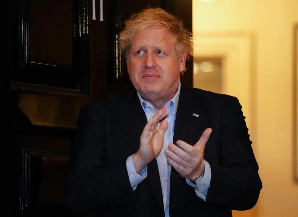 Britain's Prime Minister Boris Johnson as he participates in a national "clap for carers" to show thanks for the work of Britain's National Health Service (NHS) workers in the doorway of 10 Downing Street in central London on April 2, 2020. (Reuters)