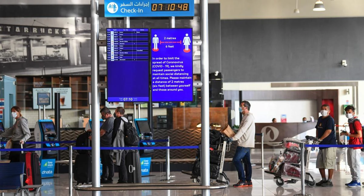 Passengers bound for Frankfurt wait while maintaining distance from each other at Dubai International Airport on April 6, 2020, as Emirates Airline resumed a limited number of outbound passenger flights after its COVID-19 coronavirus-enforced stoppage. (AFP)