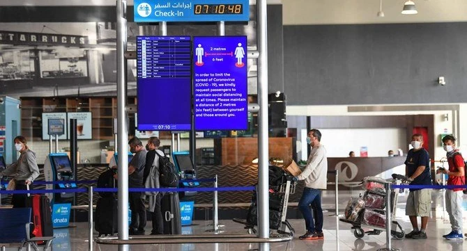 Passengers bound for Frankfurt wait while maintaining distance from each other at Dubai International Airport on April 6, 2020, as Emirates Airline resumed a limited number of outbound passenger flights after its COVID-19 coronavirus-enforced stoppage. (AFP)