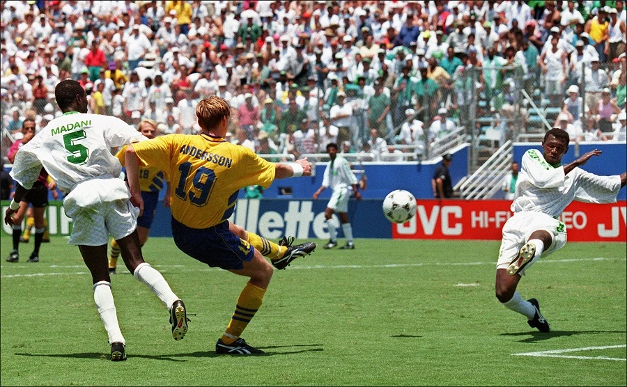 Swedish striker Kennet Andersson (C) kicks a ball as Saudi Arabian Ahmed Madani attempt to stop him, 03 July 1994 in Dallas, during the World Cup soccer match between Sweden and Saudi Arabia. (AFP/Mike Nelson)