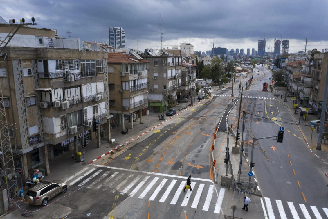 Ultra-Orthodox Jews cross an empty road during a lockdown to help stop the spread of the coronavirus, in Bnei Brak, a suburb of Tel Aviv, Israel, Tuesday, April 7, 2020. (AP/Oded Balilty)