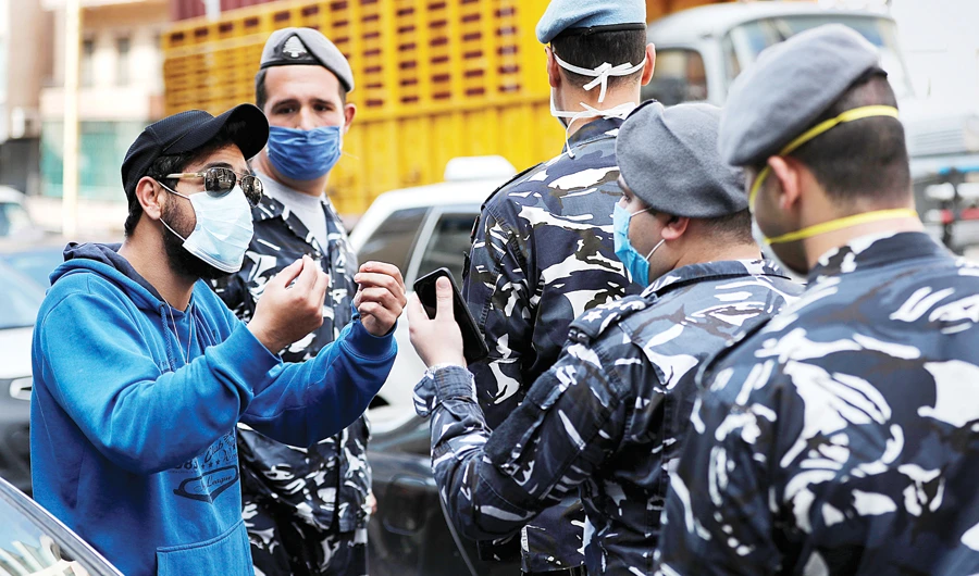 A driver argues with Lebanese policemen after receiving a fine for violating strict measures against the spread of the coronavirus disease (COVID-19), in Beirut on Tuesday. (AP)