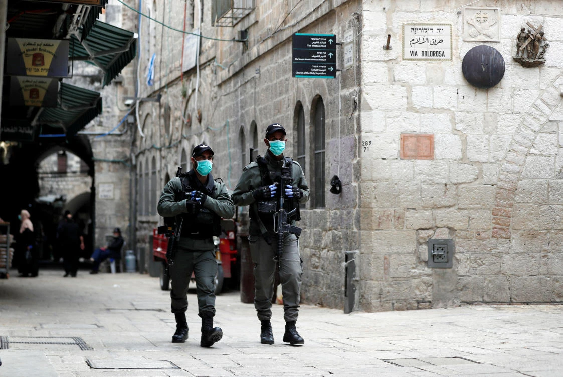 Above, Israeli police wearing masks patrol a street in Jerusalem’s Old City. Domestic intelligence agency Shin Bet said an Israeli man had been in contact with Iranian intelligence to recruit Israeli Arabs to carry out the attacks. (Reuters)