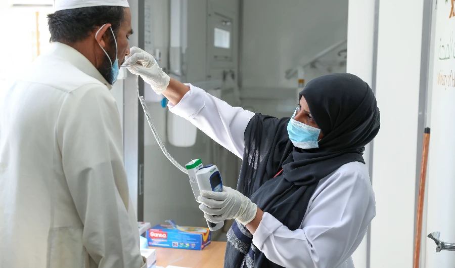A Saudi nurse checks a patient's temperature at a mobile clinic catering for the residents of Ajyad Almasafi district in the holy city of Mecca, on April 7, 2020. (AFP)