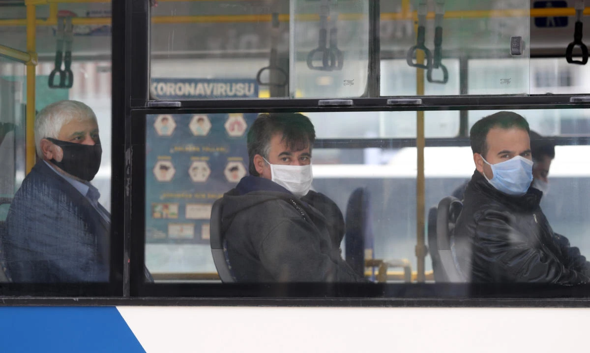 People wear protective masks look on in a bus in Ankara, on April 6, 2020. (AFP)