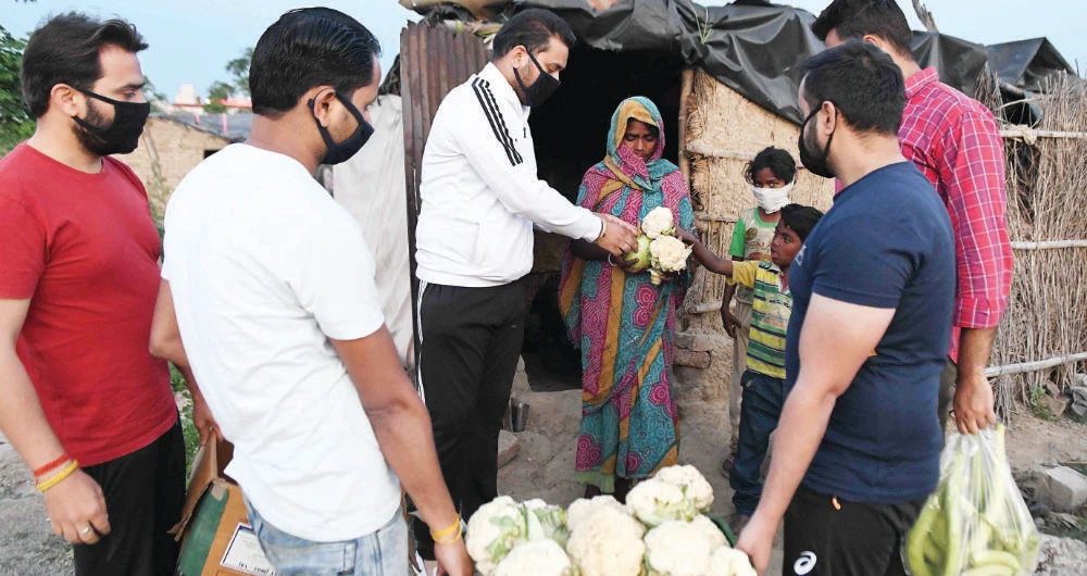 Volunteers distribute food to people in need during a government-imposed nationwide lockdown as a preventive measure on the outskirts of Amritsar on Wednesday. (AFP)