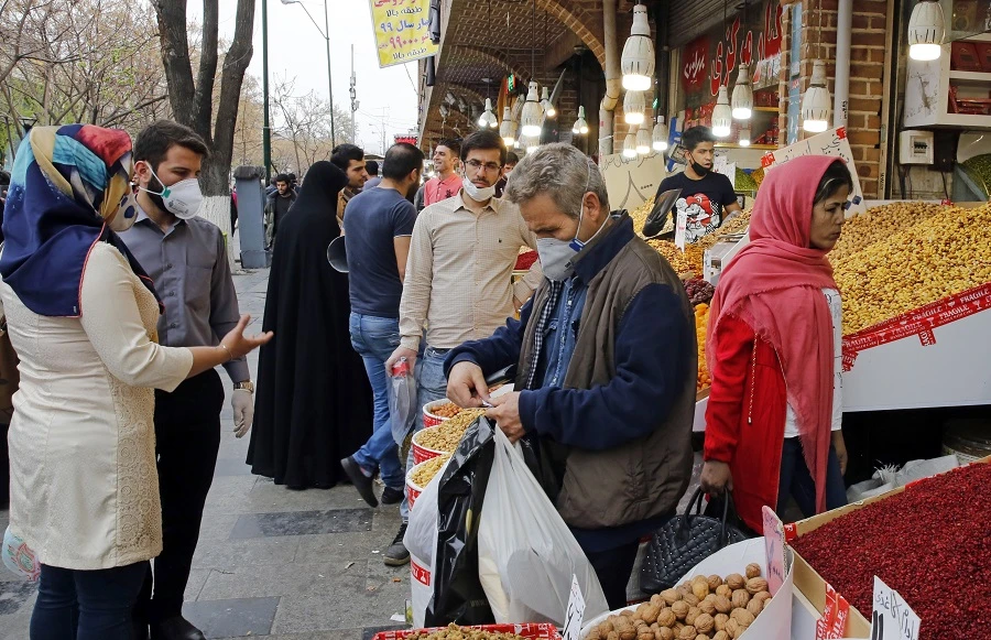 Iranians, some wearing protective masks, gather around the capital Tehran's grand bazaar, during the Covid-19 coronavirus pandemic crises, on March 18, 2020. (File/AFP)