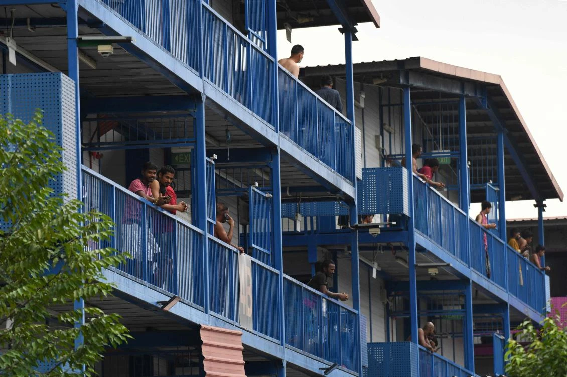 This file photo taken on April 6, 2020 shows foreign workers hanging out along the corridor of the S11 Dormitory @ Punggol, where there are numerous cases of individuals with the COVID-19 novel coronavirus in Singapore. (AFP)