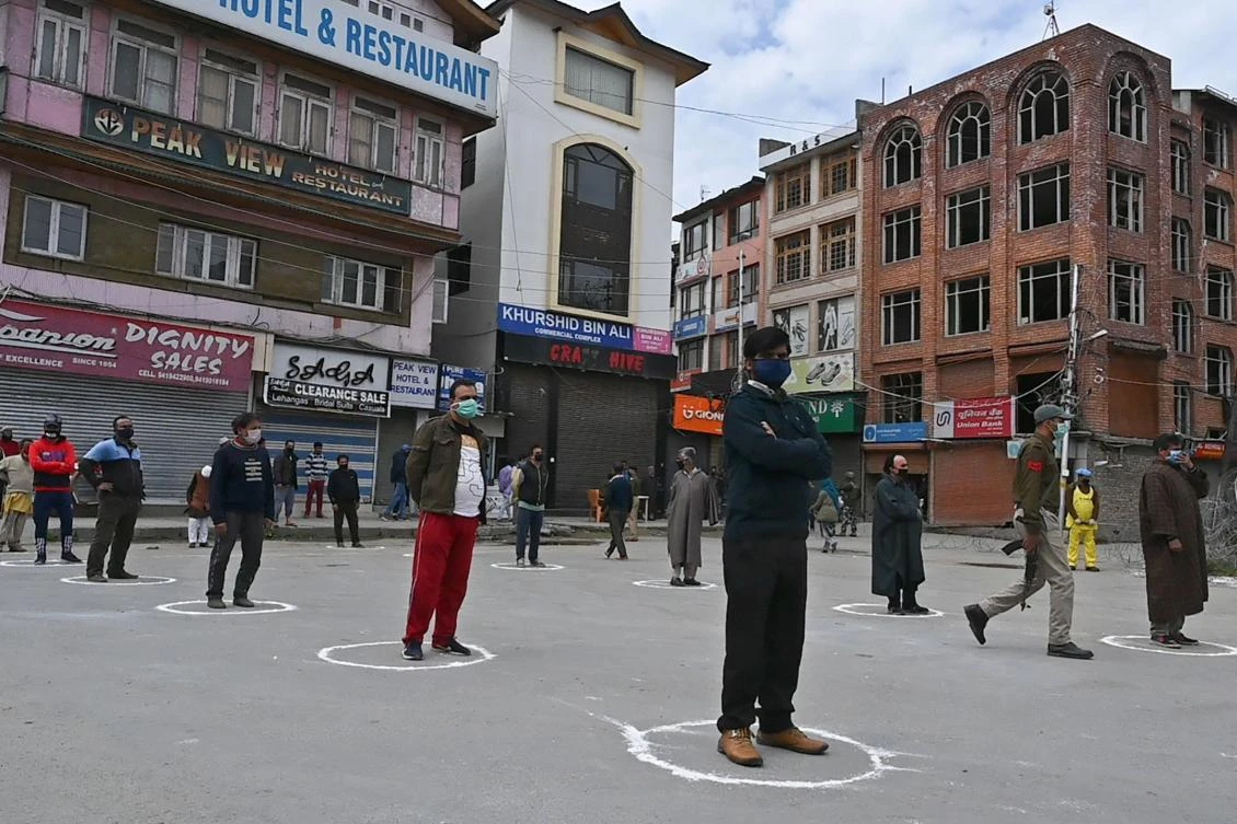 People maintain social distance as Indian paramilitary personnel distributes food for those in need during a government-imposed nationwide lockdown as a preventive measures against the spread of the COVID-19 coronavirus in Srinagar on April 9, 2020. (AFP)
