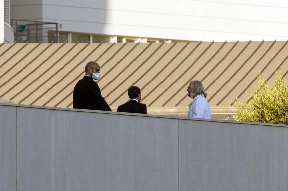 French President Emmanuel Macron, center, speaks with Professor Didier Raoult, right, at the Mediterranean institute of infection in Marseille, southern France, Thursday, April 9, 2020. (AP Photo)