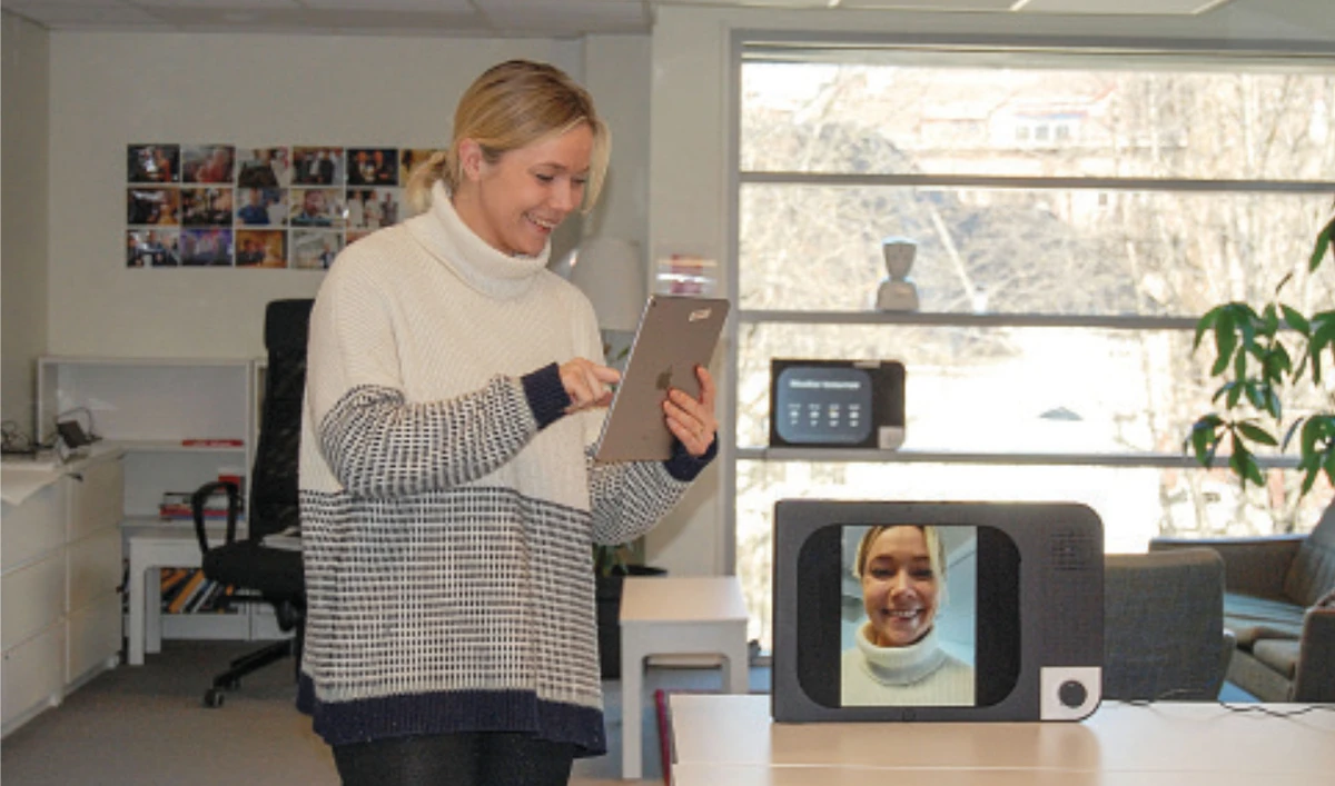 Face time: Karen Dolva, CEO of No Isolation, uses a tech device called Komp, which allows older people to receive messages and two-way family video calls. (AFP)