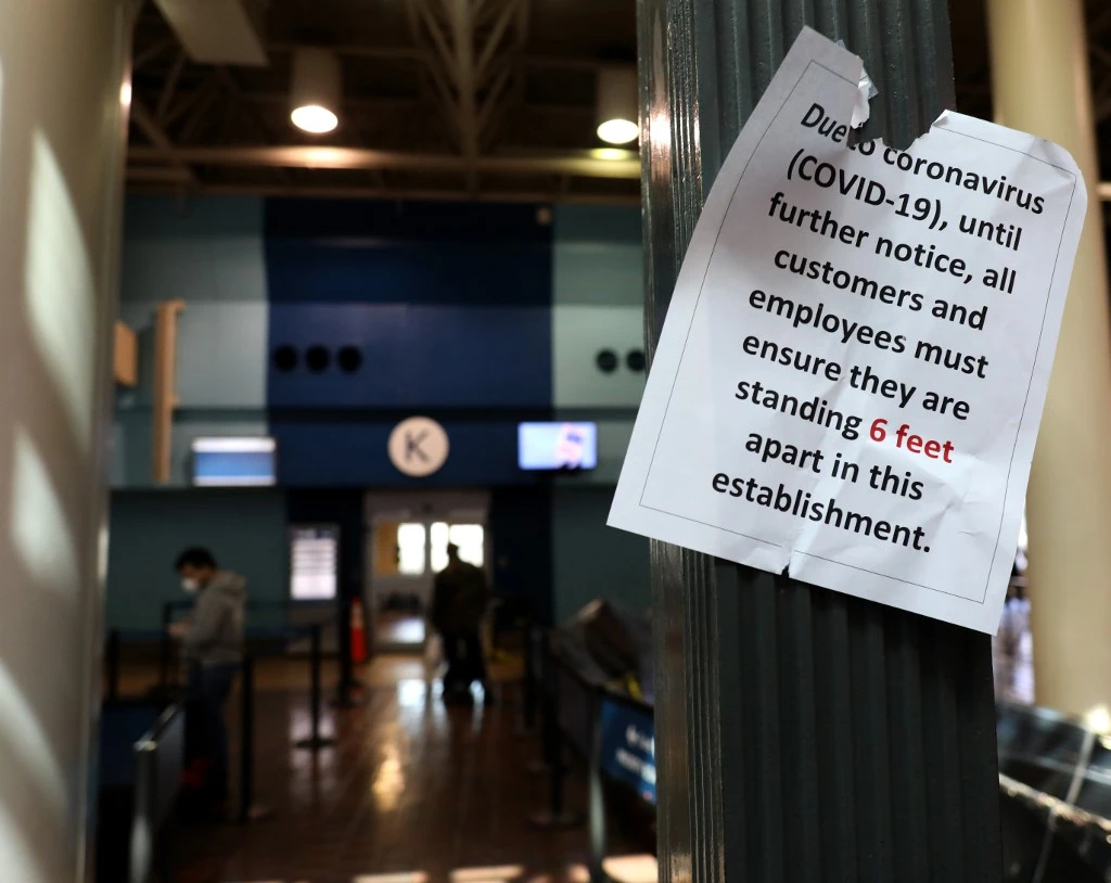 A sign encouraging social distancing hangs in the boarding area at an Amtrak gate at Union Station on April 09, 2020 in Washington, DC. (Getty Images via AFP)