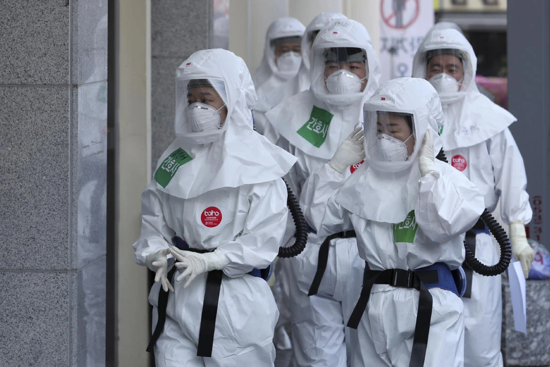 Medical staff members arrive for a duty shift at Dongsan Medical Center in Daegu, South Korea. Daegu accounts for more than half of all South Korea’s 10,450 infections. (Yonhap via AP)