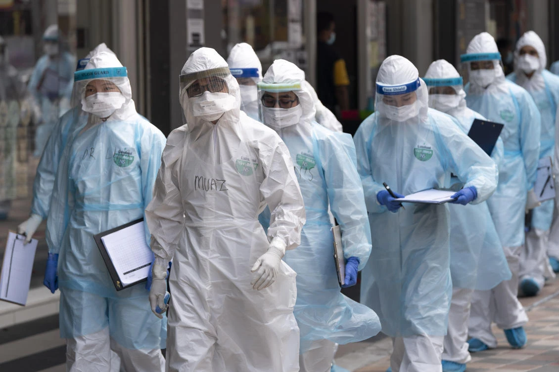 Medical workers in protective suits entering a building under lockdown in downtown Kuala Lumpur, Malaysia, on Tuesday, April 7, 2020. (AP)