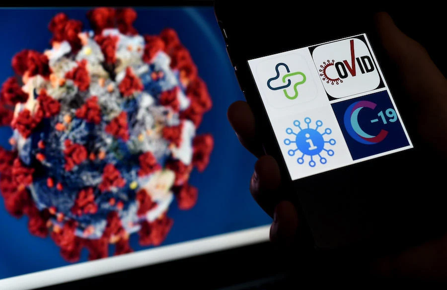 Coronavirus tracking applications logos, Healthlynked Covid-19, Covid Symptom Tracker, Apple Covid-19, Covid-19 tracker, are seen displayed on a smartphone. (AFP)