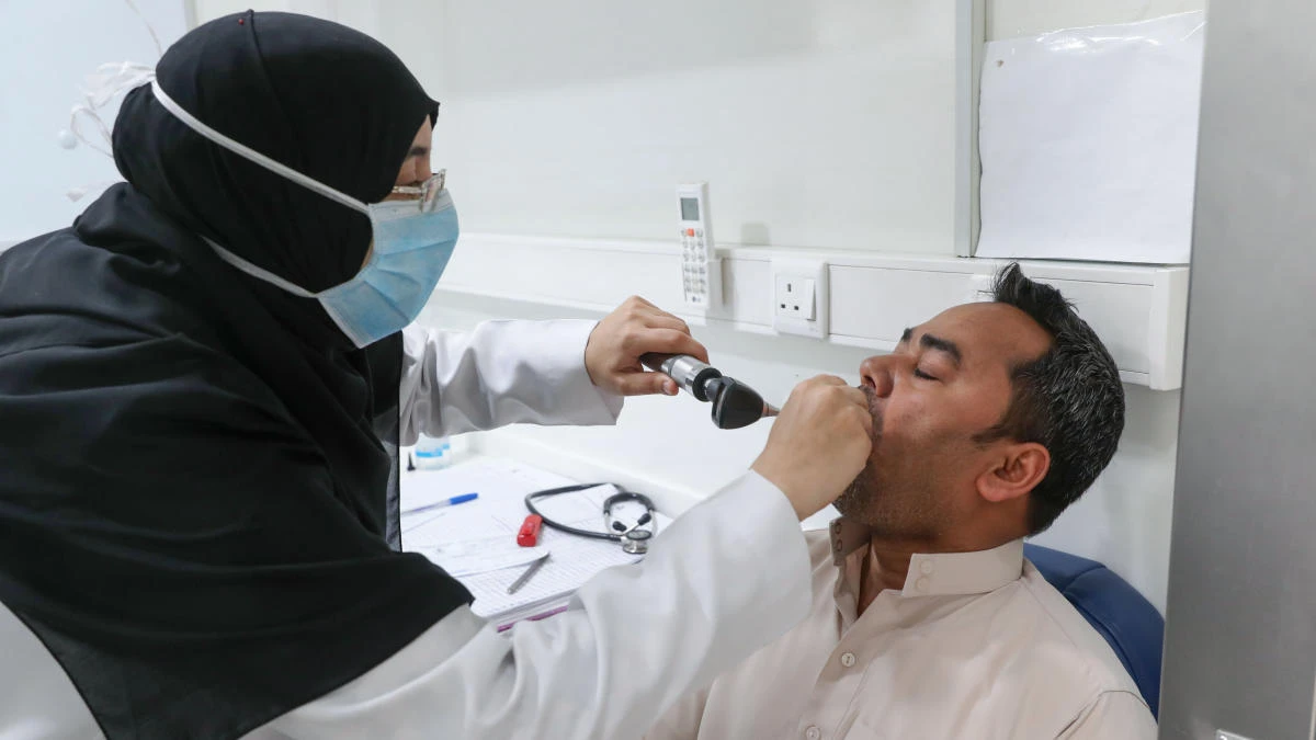A Saudi nurse checks a patient at a mobile clinic catering for the residents of Ajyad Al-Masafi district in Makkah, on April 7, 2020. (AFP)