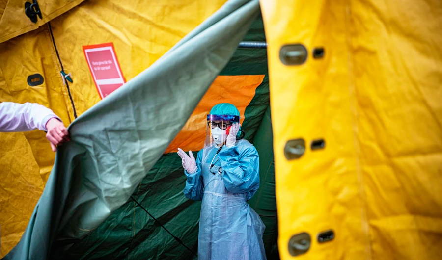 A medical staffer at Sophiahemmet hospital talks on a cell phone inside a tent for testing and receiving potential coronavirus COVID-19 patients on April 7, 2020 in Stockholm. (AFP)