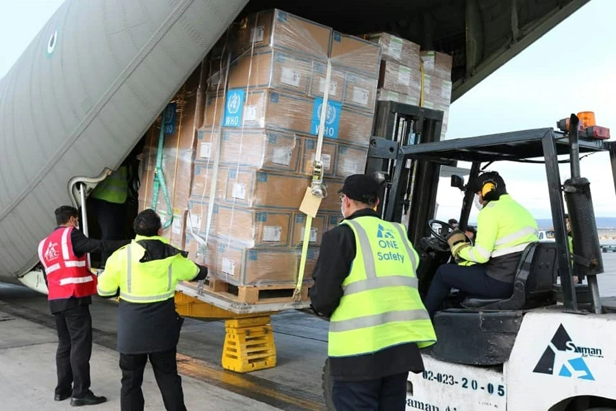 A handout picture released by the World Health Organization (WHO) on March 2, 2020, shows labourers unloading medical equipment and coronavirus testing kits provided bt the World Health Organisation, from a United Arab Emirates military transport plane upon their arrival at Mehrabad International Airport in Iran's capital Tehran. (File/AFP)