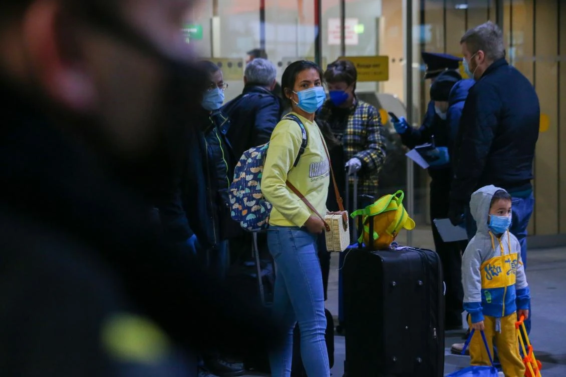 Russian citizen, wearing face masks to protect against coronavirus, walk upon their arrive from Thailand at Sheremetyevo international airport outside Moscow, Russia, Wednesday, April 8, 2020. (AP)