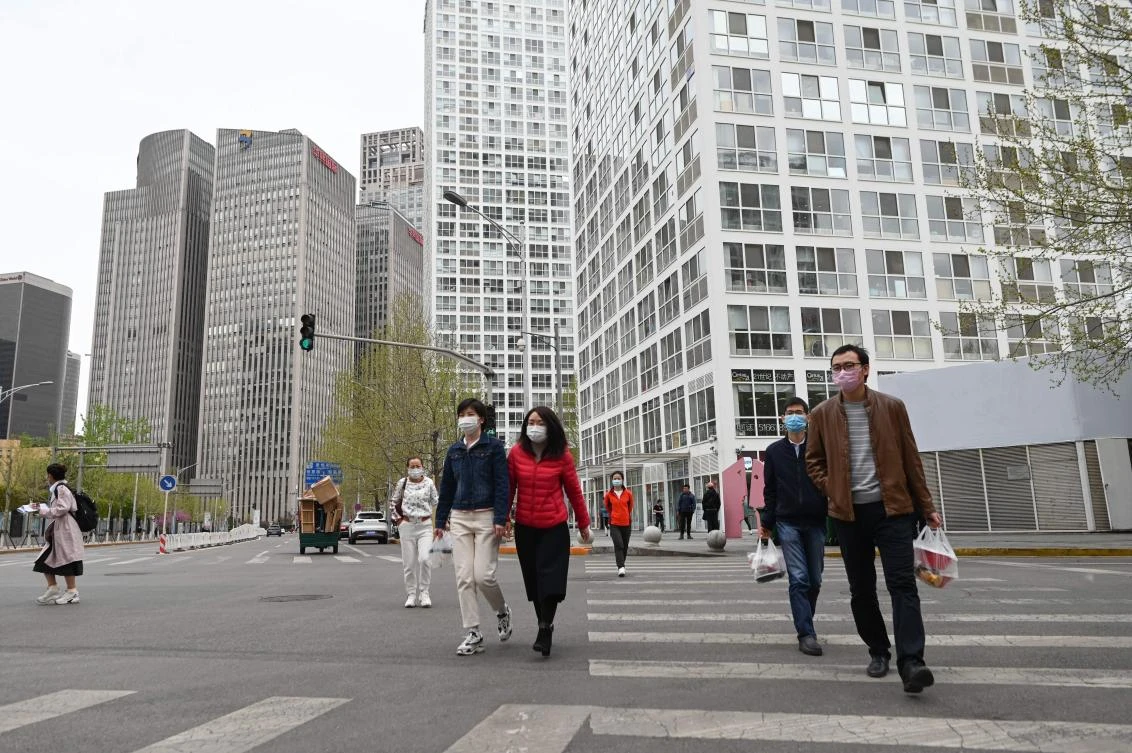 Pedestrians wearing face masks cross a street in Beijing on April 8, 2020. (AFP)