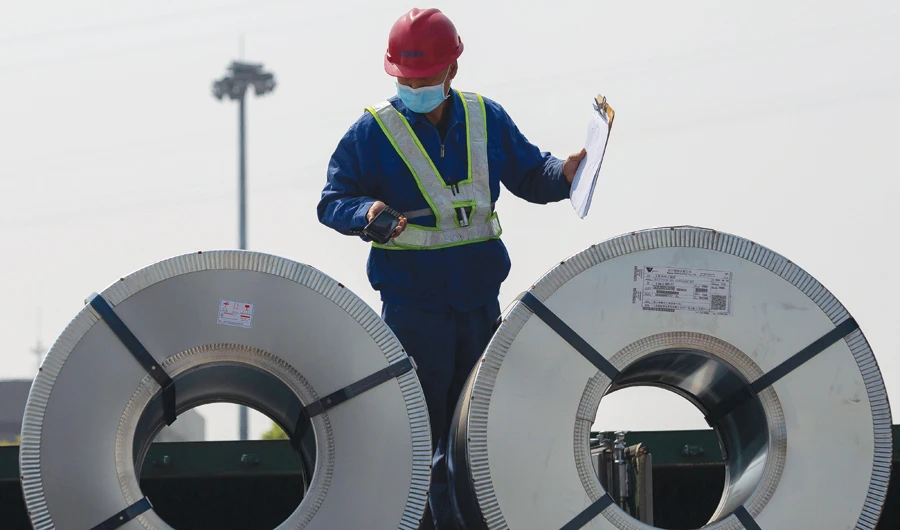 A worker checks rolls of steel at the port in Wuhan, on the Yangtze river, in China’s central Hubei province on Sunday. (AFP)