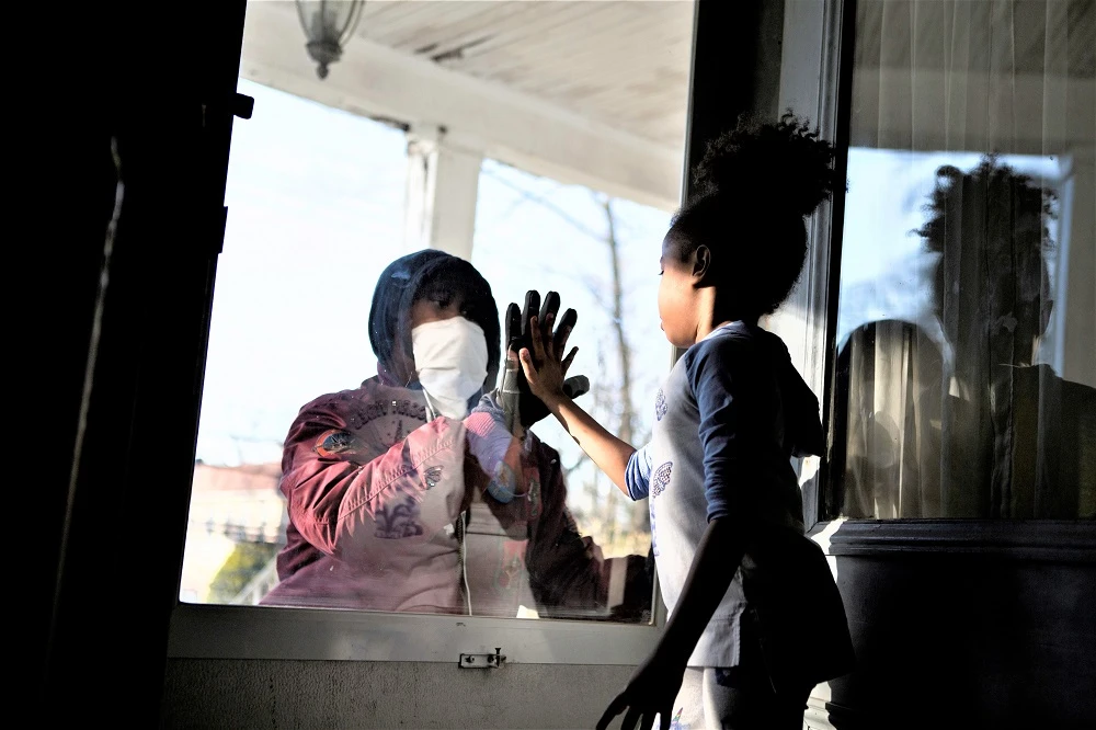 A healthcare frontliner greets his daughter through the closed door as he maintains social distance from his family amid the coronavirus disease outbreak in New York, in this April 11, 2020 photo. (Reuters)